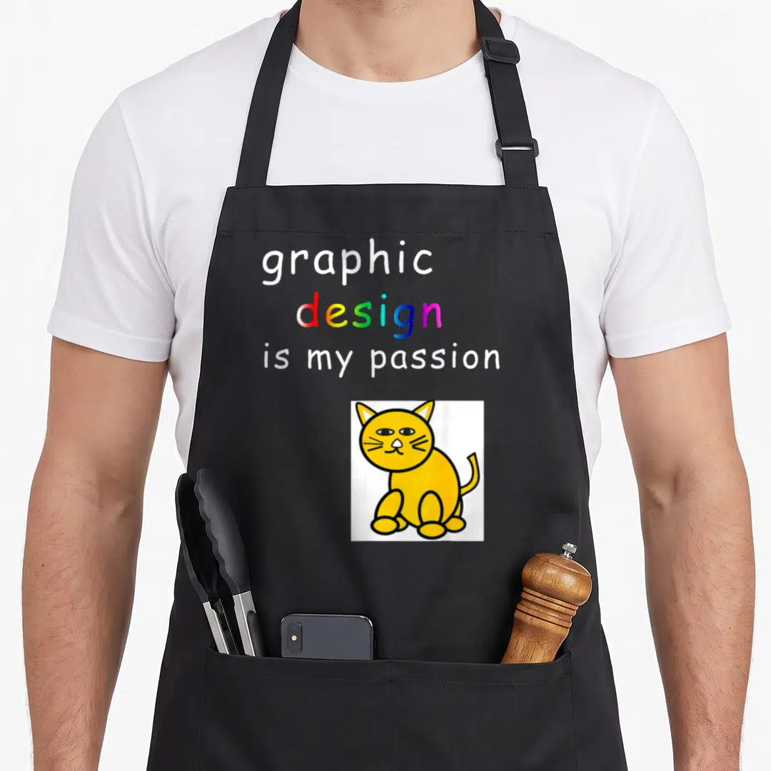 Passion designer apron - Stacked text graphic design is my passion above yellow cartoon cat on white square — shown on a black cotton canvas apron against a white background