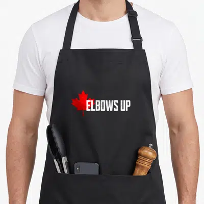 Elbow canada aprons - Red maple leaf and white distressed ELBOWS UP text on black fabric — shown on a black cotton canvas apron against a white background