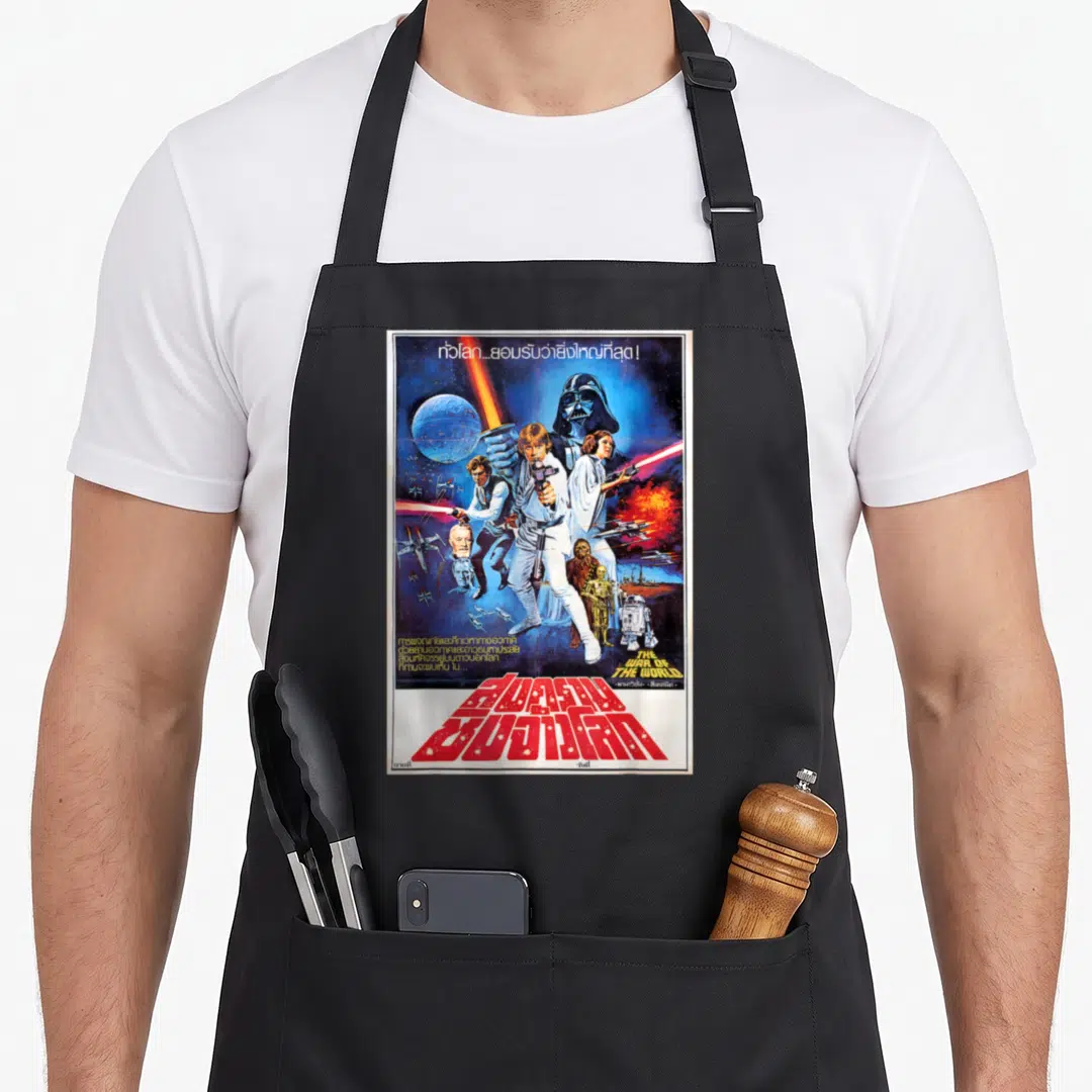 Thai new hope apron - Vintage Star Wars poster with misprinted English title and bold red Thai script over character — shown on a black cotton canvas apron against a white background