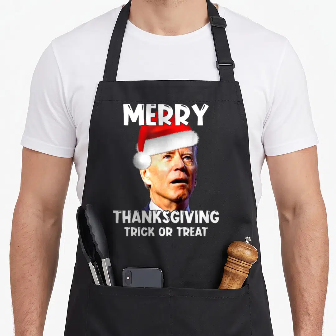 Joe santa aprons - Photo of Joe Biden in red Santa hat with white text Merry Thanksgiving Trick or Treat — shown on a black cotton canvas apron against a white background