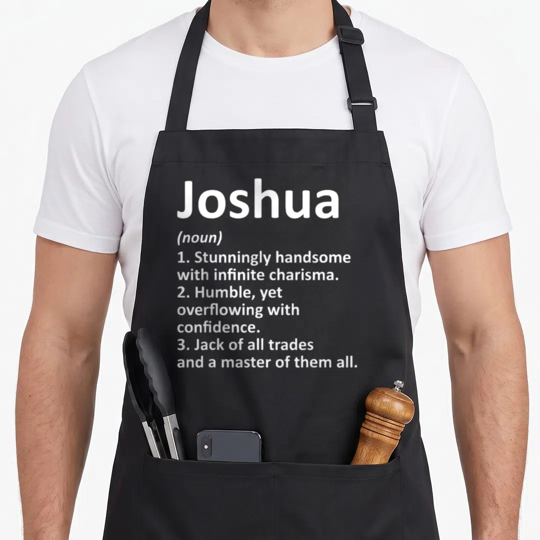 Meaning father day aprons - White text defining Joshua as handsome and a master of trades on gray background — shown on a black cotton canvas apron against a white background