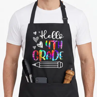 Teacher tie-dye apron - Hello 4th Grade tie-dye text with white hearts and pencil outline on apron — shown on a black cotton canvas apron against a white background