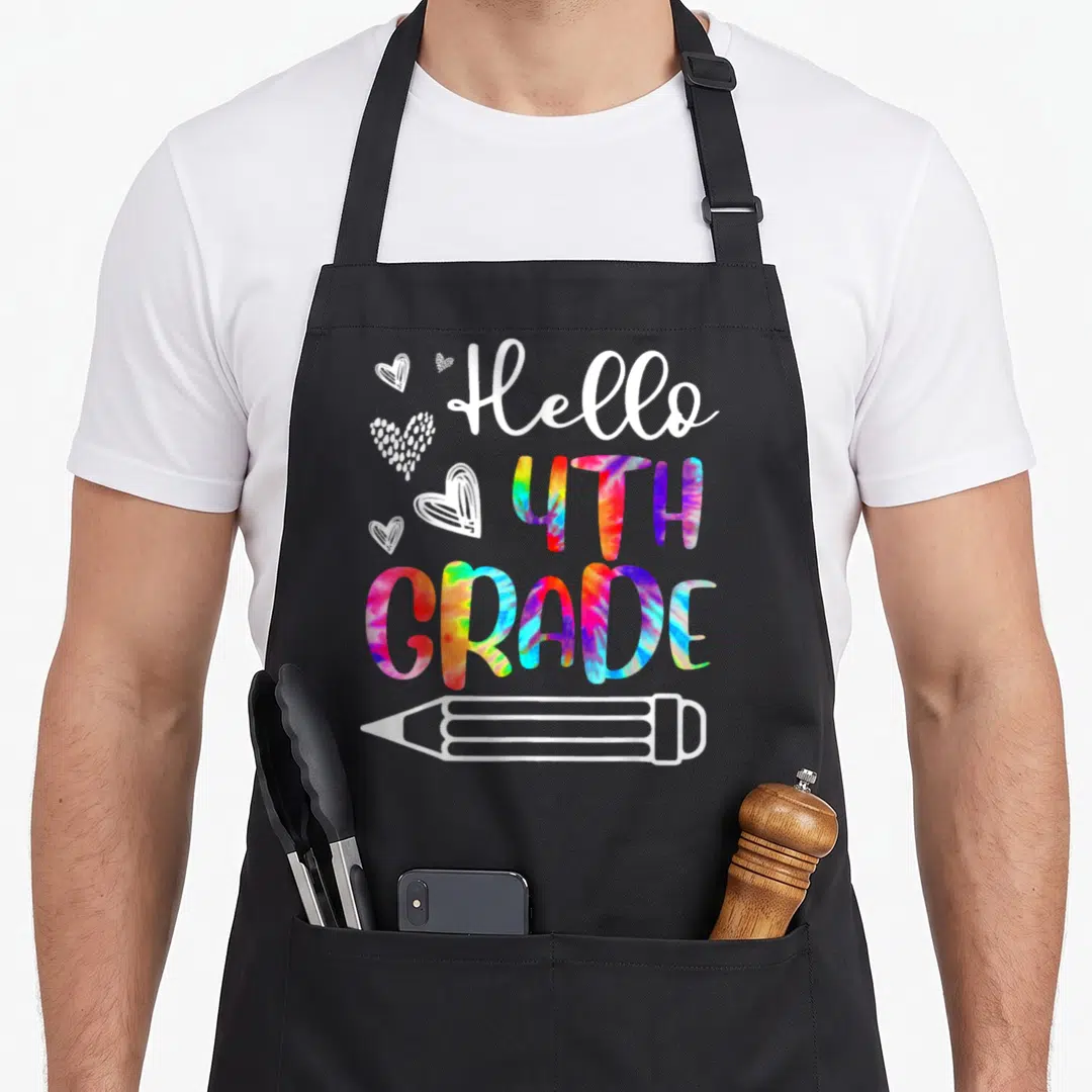 Teacher tie-dye apron - Hello 4th Grade tie-dye text with white hearts and pencil outline on apron — shown on a black cotton canvas apron against a white background