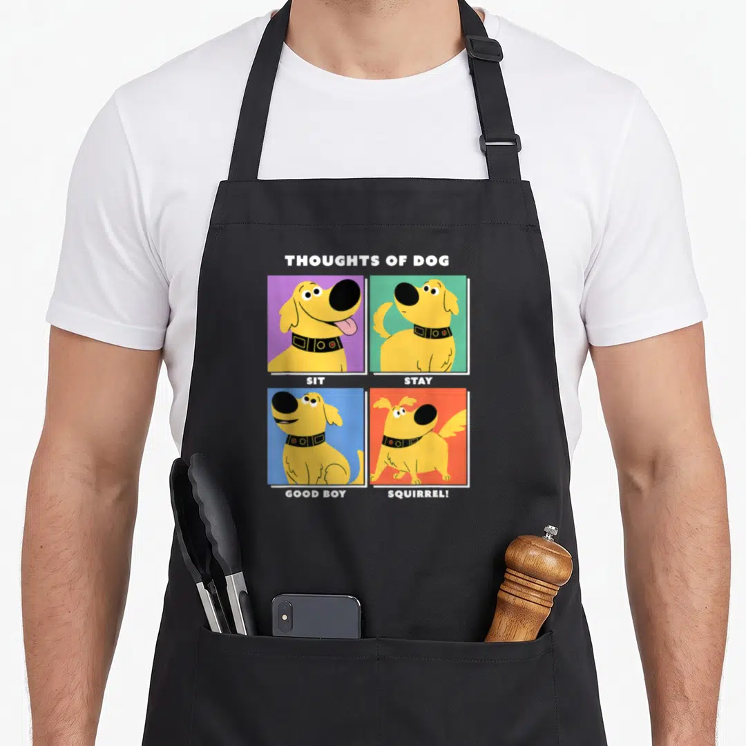 Dug dog apron - Yellow cartoon dog on purple green blue and orange squares with text Sit Stay Good Boy Squirrel — shown on a black cotton canvas apron against a white background