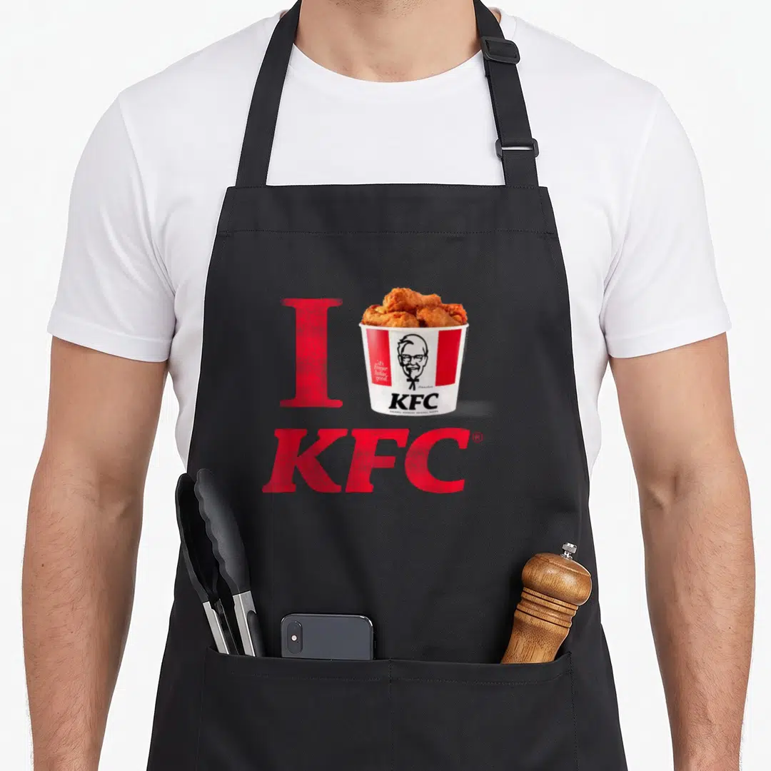 Bucket chicken apron - Red I and KFC letters flanking a photo of a fried chicken bucket — shown on a black cotton canvas apron against a white background