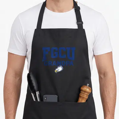 Gulf coast eagles apron - FGCU GRANDPA text above a white and yellow eagle head logo in navy blue — shown on a black cotton canvas apron against a white background