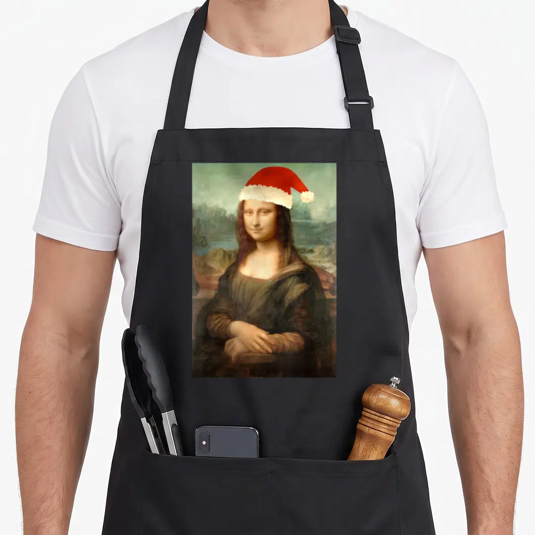 Mona christmas santa apron - Mona Lisa portrait wearing a red and white Santa hat over a blue landscape background — shown on a black cotton canvas apron against a white background