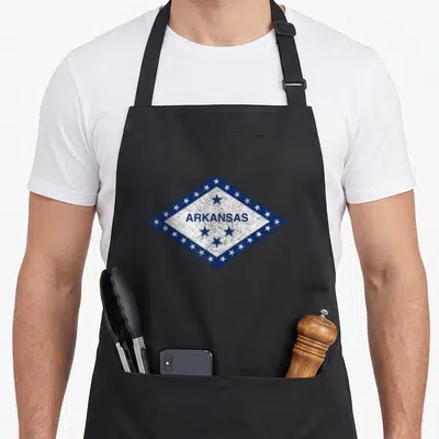 Natural arkansas apron - Blue and white diamond shape containing ARKANSAS text surrounded by white and blue stars — shown on a black cotton canvas apron against a white background