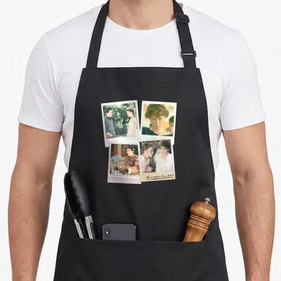Sixteen candle apron - Four overlapping polaroid photos in white beige green pink with Sixteen Candles text on bottom — shown on a black cotton canvas apron against a white background