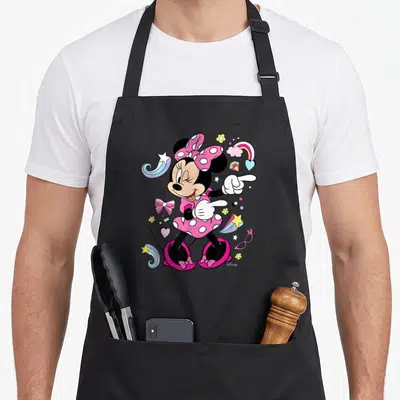 Vintage friends apron - Minnie Mouse pointing surrounded by stars, hearts, rainbow, and glasses in pink and black — shown on a black cotton canvas apron against a white background