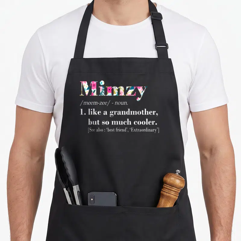 Mimzy grandmother apron - Mimzy text filled with pink green and blue floral pattern defining cool grandmother — shown on a black cotton canvas apron against a white background