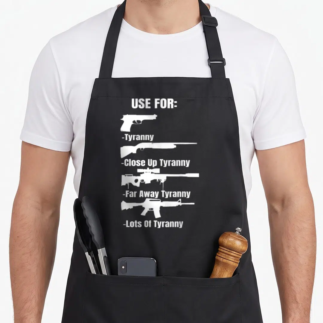 Amendment gun apron - White text Use For Tyranny with pistol shotgun sniper rifle and ar15 silhouettes stacked — shown on a black cotton canvas apron against a white background