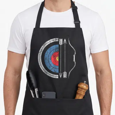 Marksman bow apron - Distressed archery target, three arrows, and bow in white blue red and yellow graphics — shown on a black cotton canvas apron against a white background