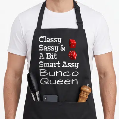 Sassy smart apron - Classy Sassy Bunco Queen text with two red dice stacked vertically — shown on a black cotton canvas apron against a white background