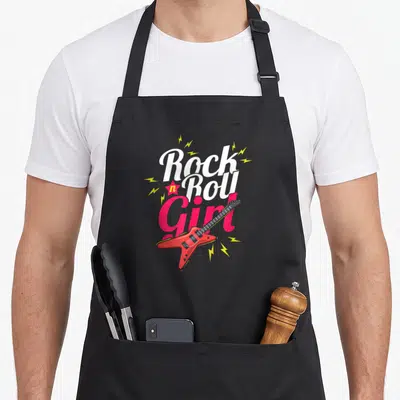 Rock festival apron - Stacked Rock n Roll Girl text with red electric guitar and yellow lightning bolts — shown on a black cotton canvas apron against a white background