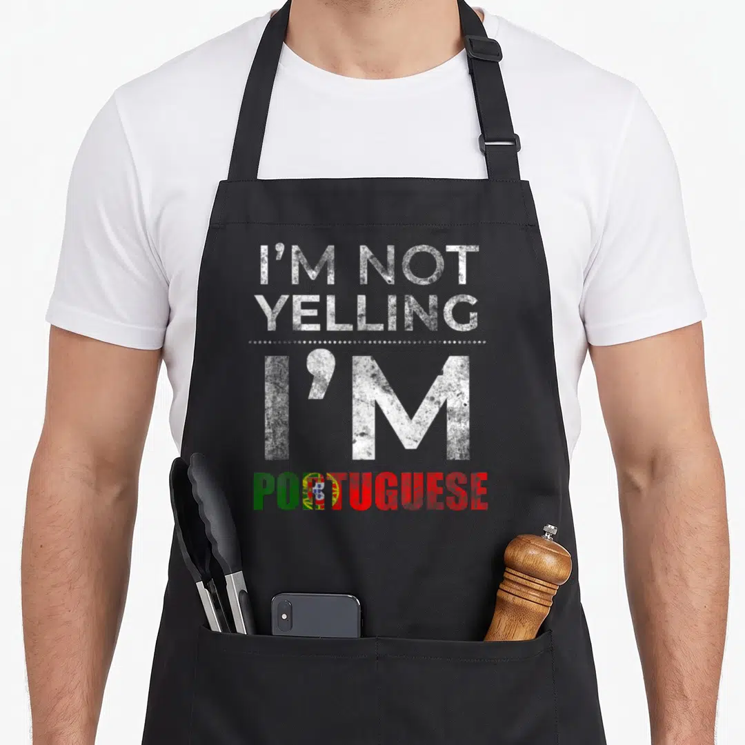 Family portuguese apron - Distressed text I'm Not Yelling I'm Portuguese with flag letter O and white dots — shown on a black cotton canvas apron against a white background