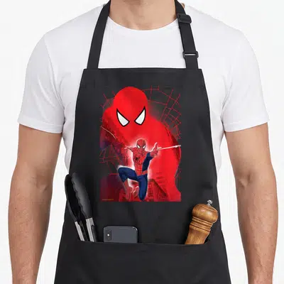 Neighborhood novelty apron - Spider-Man leaping in front of large red head silhouette with white web lines on black — shown on a black cotton canvas apron against a white background