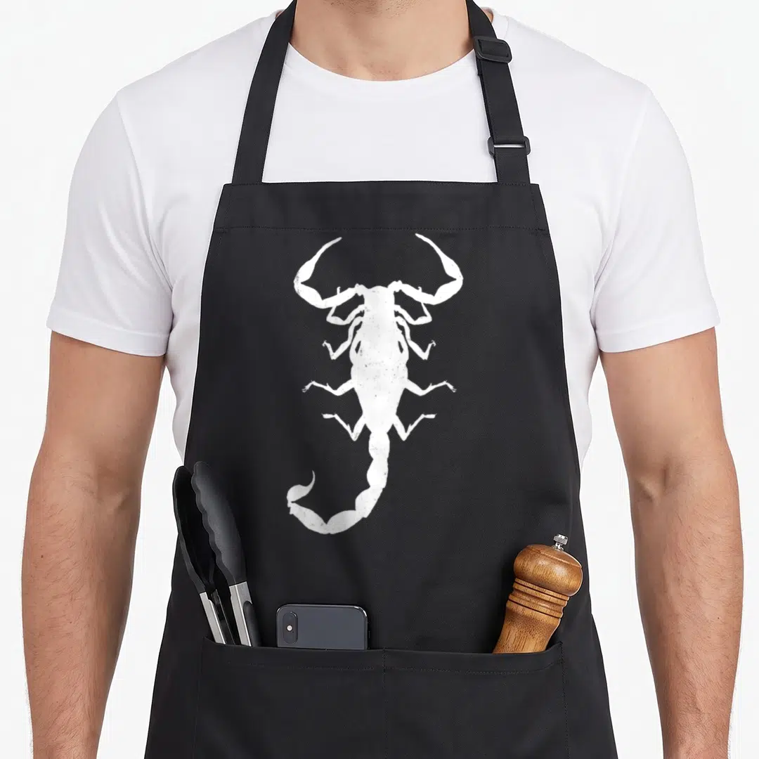 Retro scorpion apron - Distressed white scorpion silhouette centered on dark grey background — shown on a black cotton canvas apron against a white background