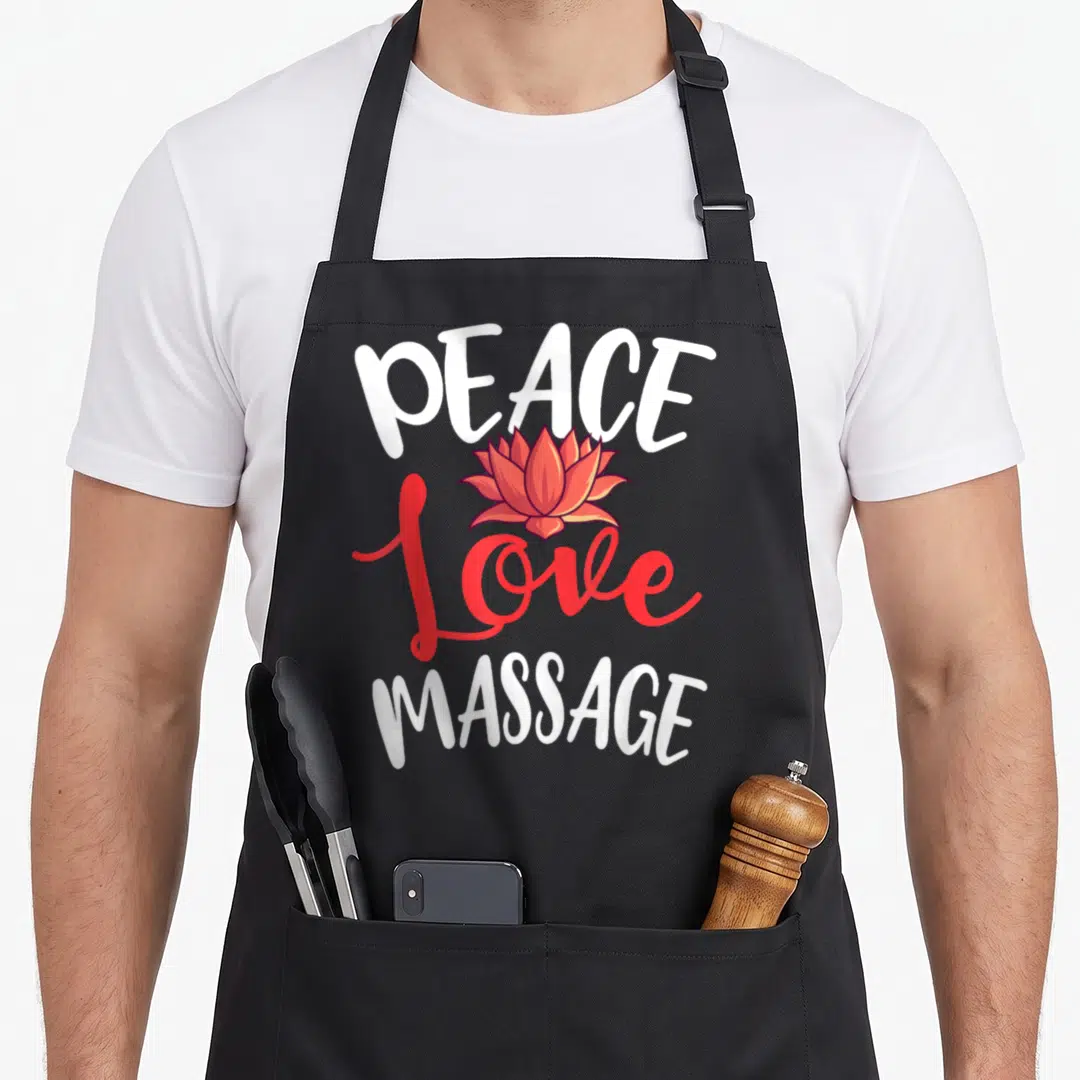 Peace massage therapist apron - PEACE Love MASSAGE text with red lotus flower graphic — shown on a black cotton canvas apron against a white background