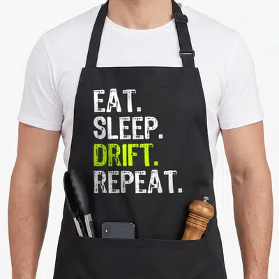 Drifter car apron - Stacked Eat Sleep Drift Repeat text in white and lime green distressed font — shown on a black cotton canvas apron against a white background