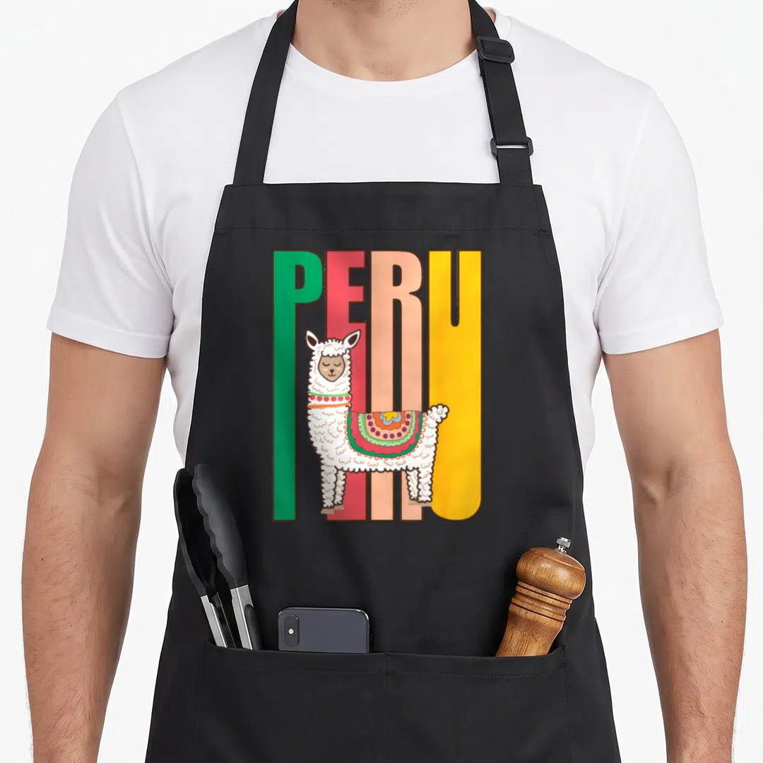 Peru alpaca apron - Cartoon llama in front of green red peach and yellow PERU block letters — shown on a black cotton canvas apron against a white background