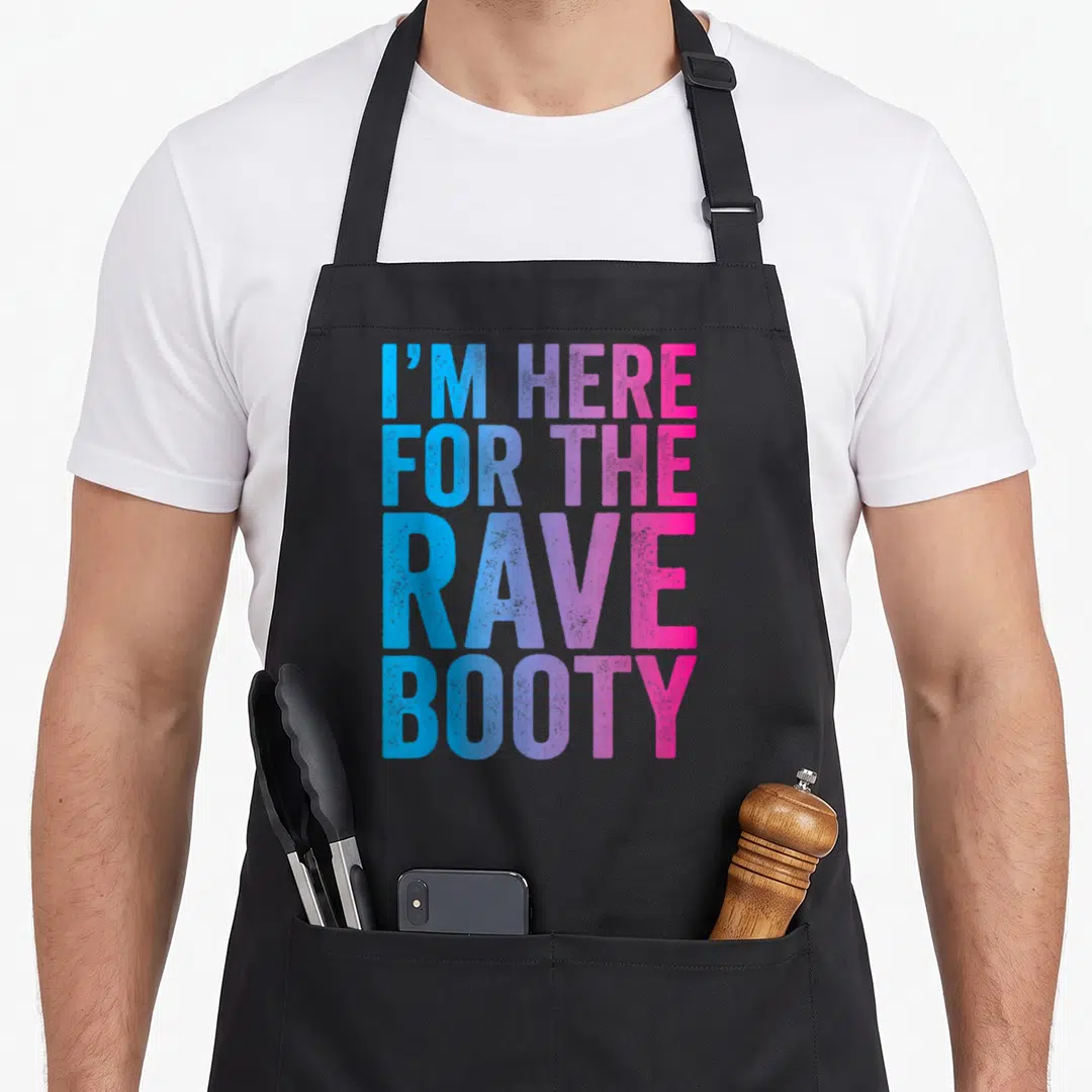 Booty edm apron - Stacked blue purple pink text reading I'M HERE FOR THE RAVE BOOTY — shown on a black cotton canvas apron against a white background