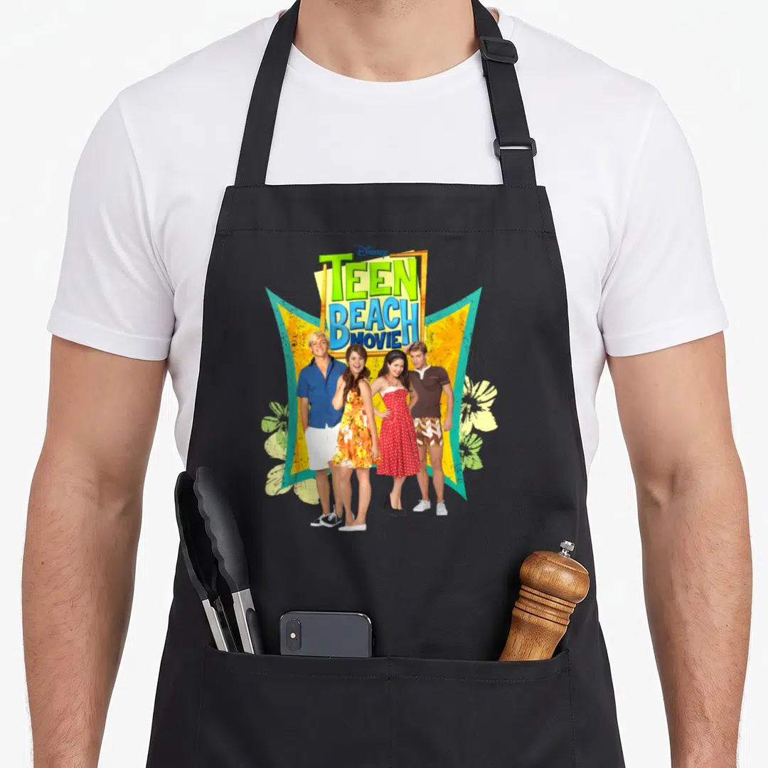Channel beach apron - Stacked Teen Beach Movie title above four people in front of yellow and teal geometric shapes — shown on a black cotton canvas apron against a white background