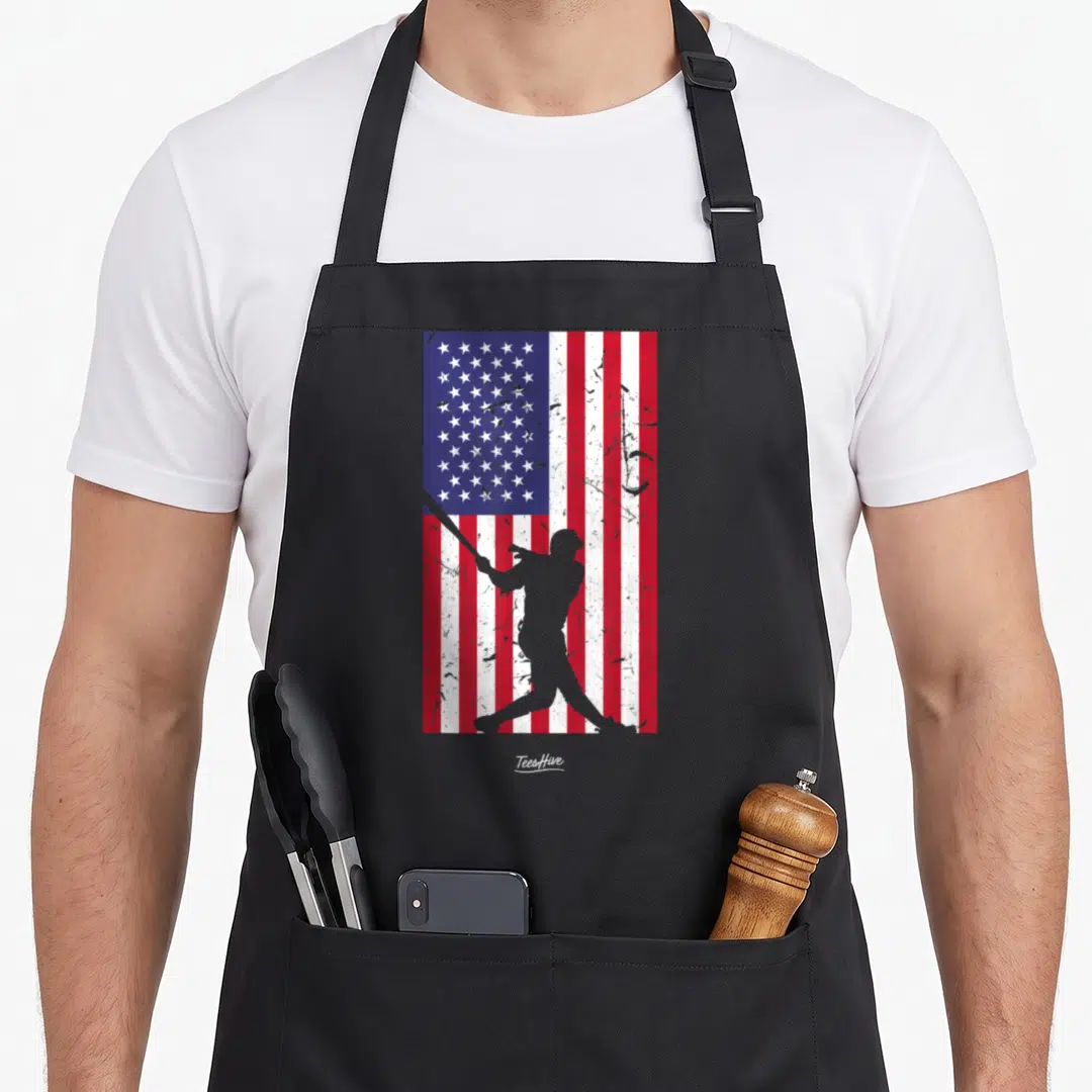 Vintage baseball american flag apron - Grey baseball batter silhouette over distressed red white and blue flag pattern — shown on a black cotton canvas apron against a white background