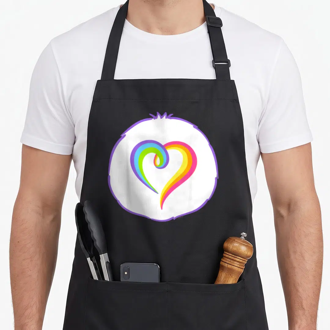 Togetherness halloween apron - Rainbow heart inside purple circle border cartoon style design — shown on a black cotton canvas apron against a white background