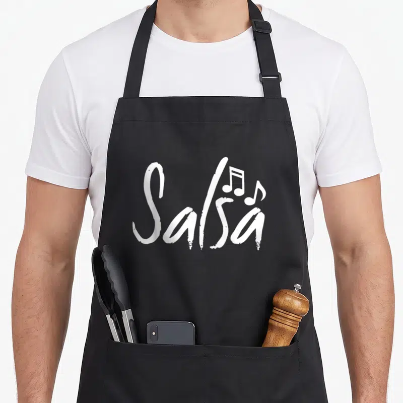 Dance pico de gallo apron - White brush script Salsa text with two musical notes on black fabric — shown on a black cotton canvas apron against a white background
