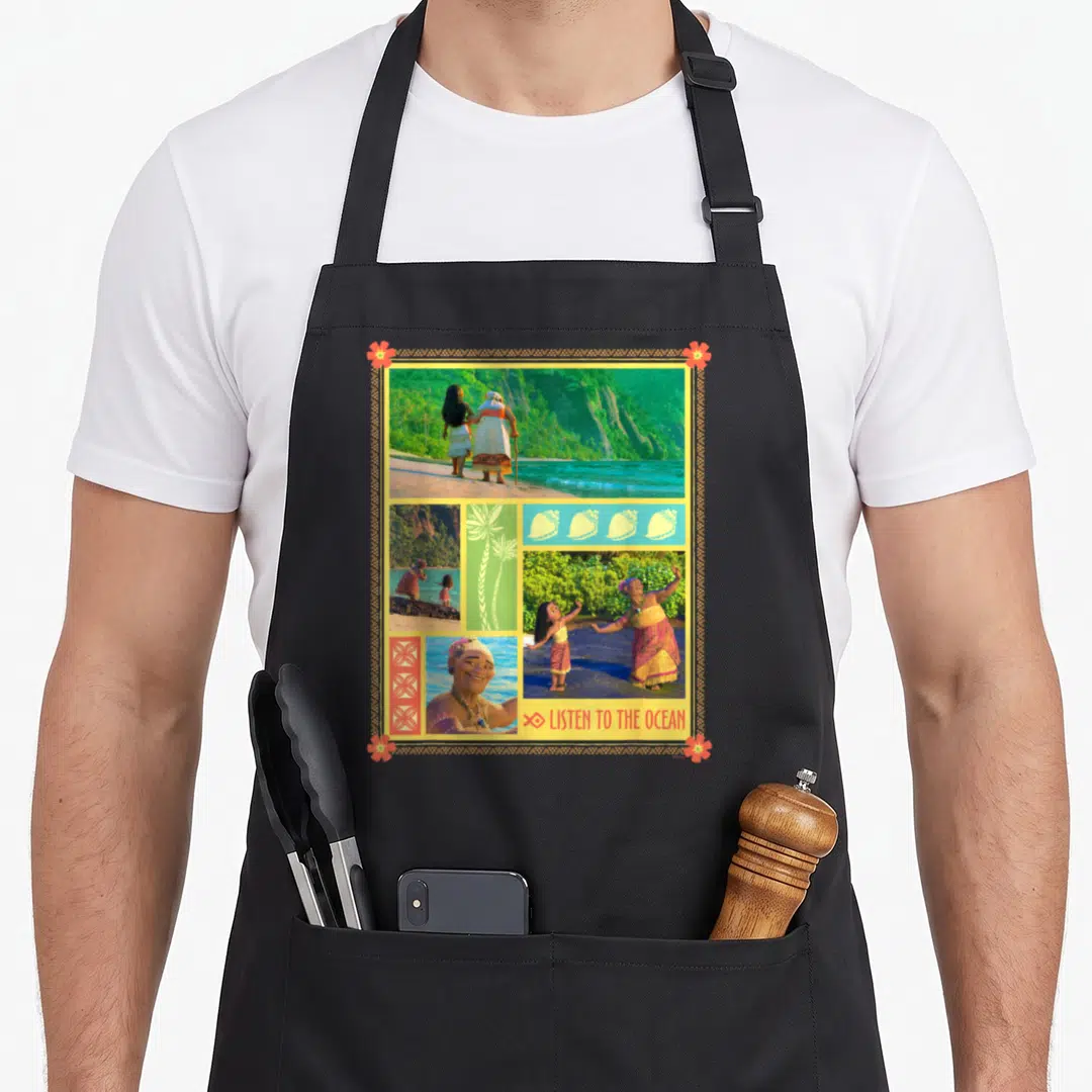 Tala gramma apron - Collage of Moana and Gramma Tala photos with Listen to the Ocean text and palm tree graphic — shown on a black cotton canvas apron against a white background