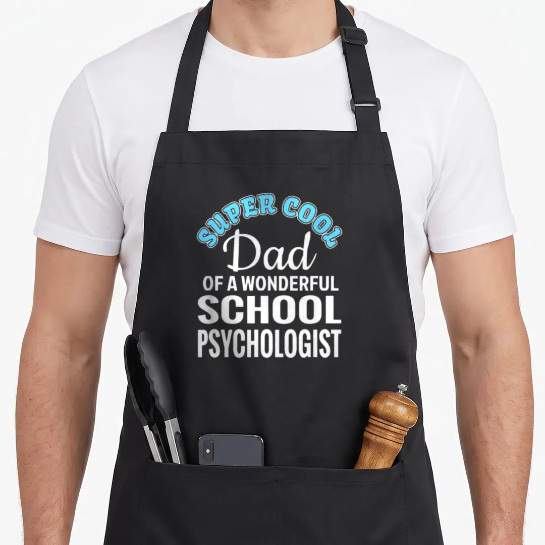 Psychologist school dad apron - Stacked white and blue text reading SUPER COOL Dad OF A WONDERFUL SCHOOL PSYCHOLOGIST — shown on a black cotton canvas apron against a white background
