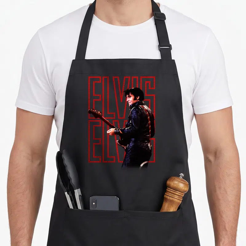Presley special aprons - Elvis Presley photo holding guitar over two stacked red dotted ELVIS outlines — shown on a black cotton canvas apron against a white background