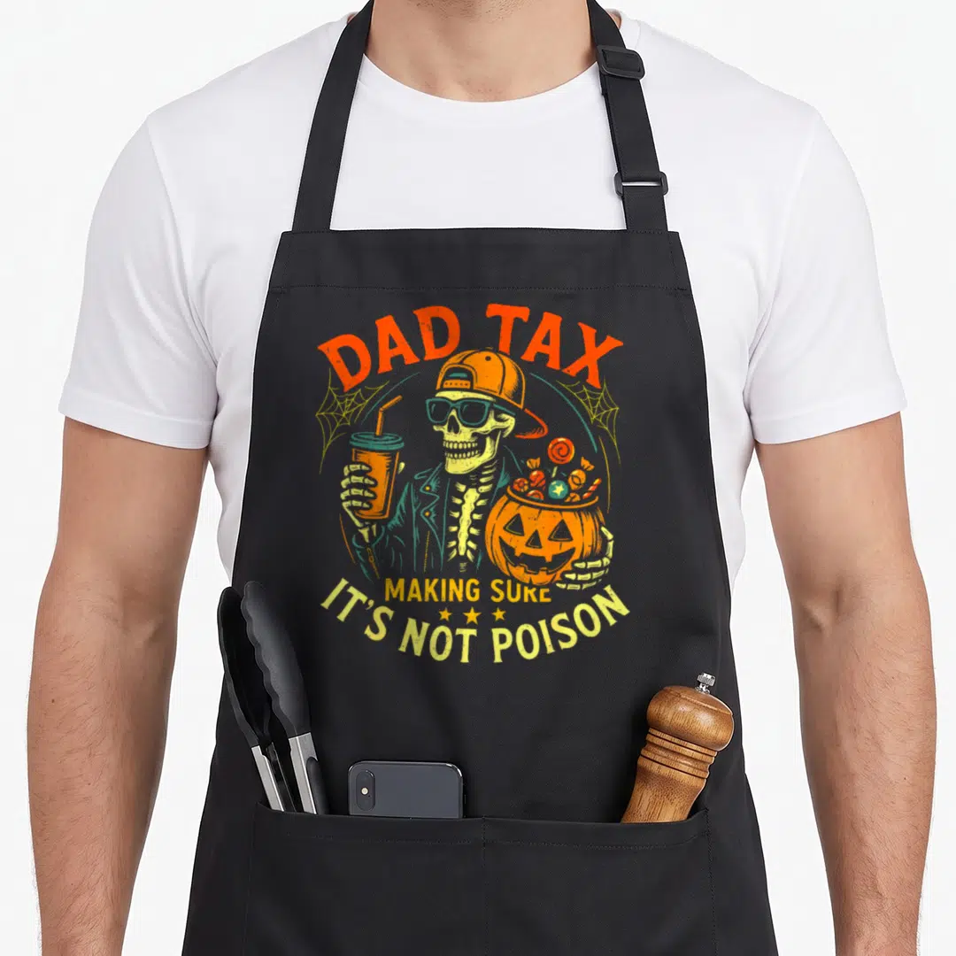Skeleton making an apron - Cartoon skeleton holding pumpkin candy bucket and drink with Dad Tax text — shown on a black cotton canvas apron against a white background