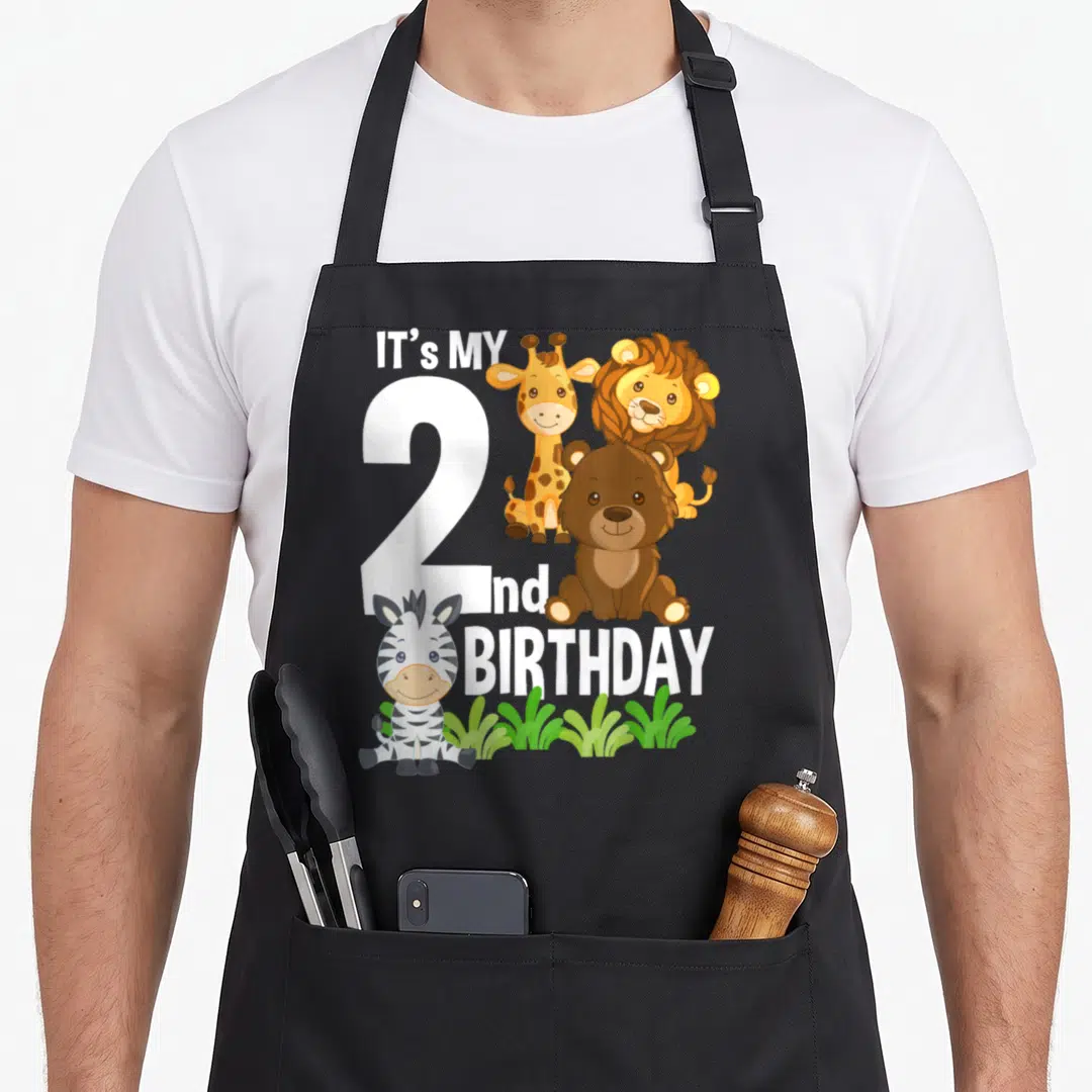 Zoo 2nd apron - Cartoon giraffe lion bear zebra around white number 2 and It's My 2nd Birthday text — shown on a black cotton canvas apron against a white background