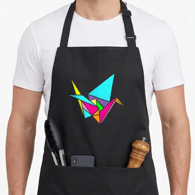 Culture paper apron - Geometric origami crane in cyan, yellow, magenta, green, purple, and orange — shown on a black cotton canvas apron against a white background