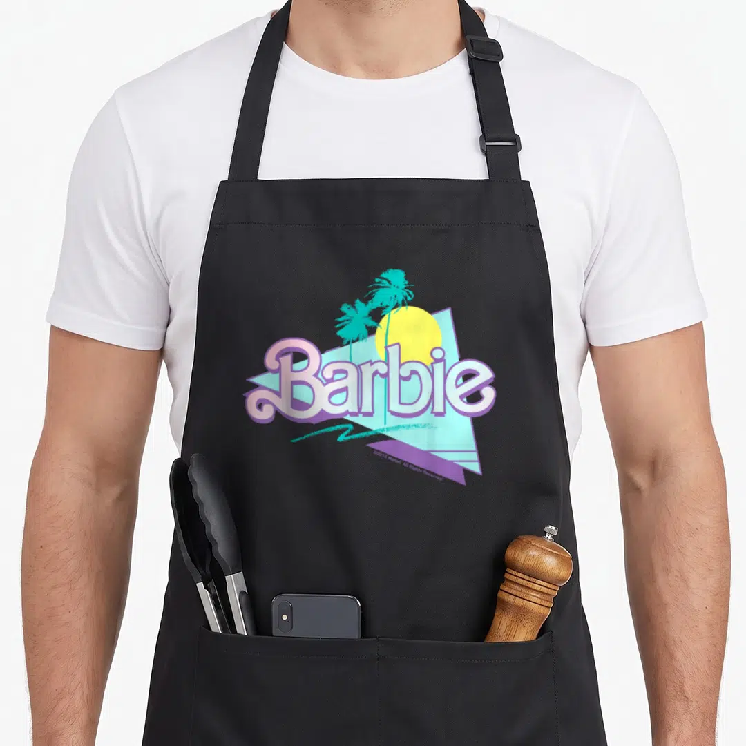 Funny 90s apron - Barbie logo over blue triangle with yellow sun and teal palm trees — shown on a black cotton canvas apron against a white background