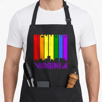 Richmond gay pride apron - RICHMOND rainbow skyline letters with purple VIRGINIA text below — shown on a black cotton canvas apron against a white background
