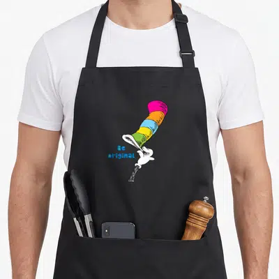 Funny original general apron - Striped top hat in pink orange yellow green blue tipped by white gloved hand next — shown on a black cotton canvas apron against a white background
