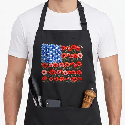 Flower american flag apron - Watercolor USA flag design made of red poppies and blue flowers with white accents — shown on a black cotton canvas apron against a white background