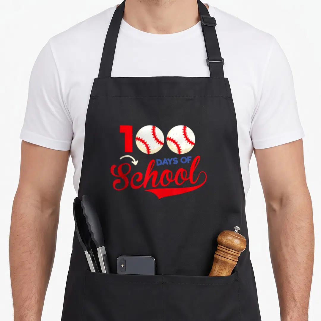 100th baseball teacher apron - Red one and two white baseballs forming 100 above DAYS OF School script — shown on a black cotton canvas apron against a white background
