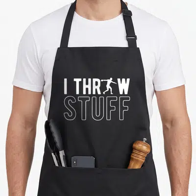 Throw discus apron - White text I THR W STUFF with person silhouette replacing O on grey background — shown on a black cotton canvas apron against a white background