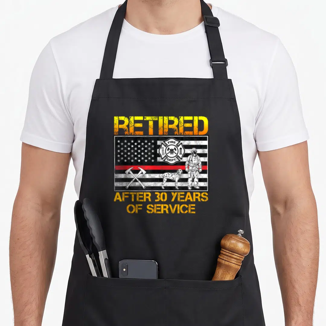 Service firefighter cooking apron - Distressed flag with firefighter dalmatian crossed axes and retired text — shown on a black cotton canvas apron against a white background