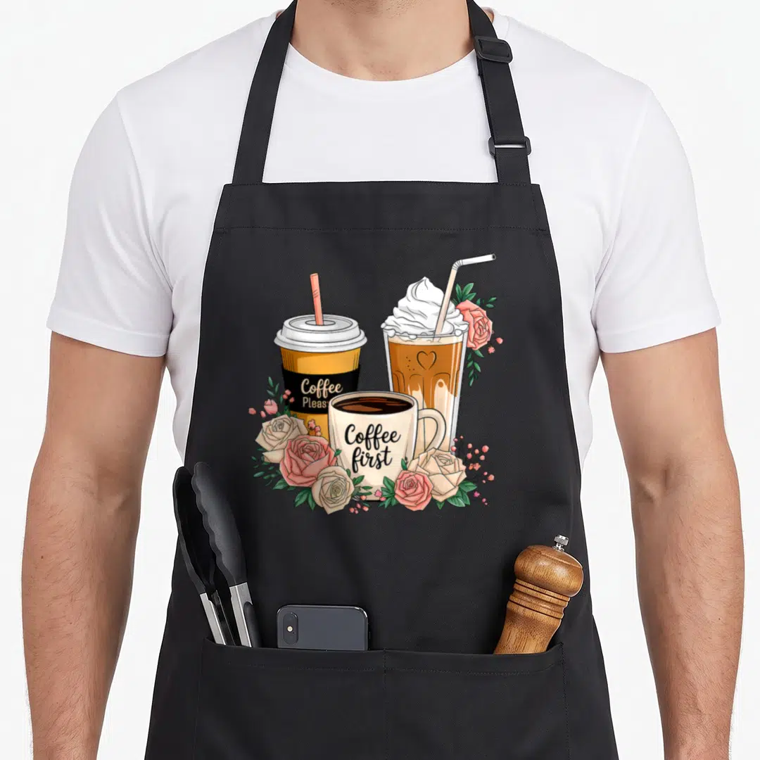 Cup floral apron - Three coffee cups with roses and text Coffee Please Coffee first — shown on a black cotton canvas apron against a white background