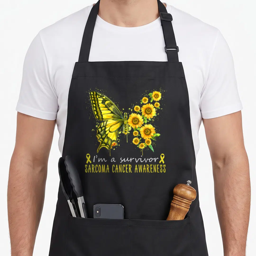 Survivor sarcoma awareness apron - Yellow butterfly with sunflower wings and I'm a survivor text on black apron — shown on a black cotton canvas apron against a white background