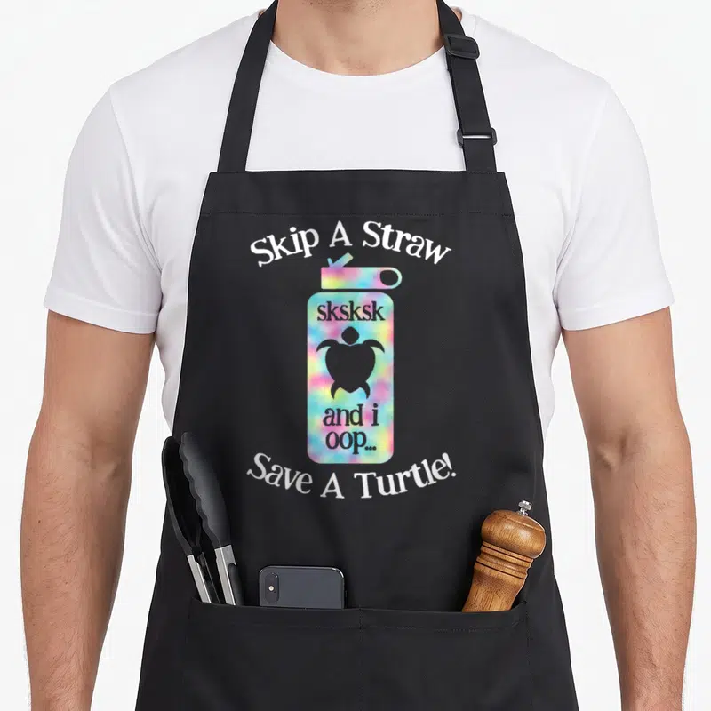Sksksk turtle lady apron - Tie-dye water bottle with turtle silhouette and Skip A Straw text — shown on a black cotton canvas apron against a white background