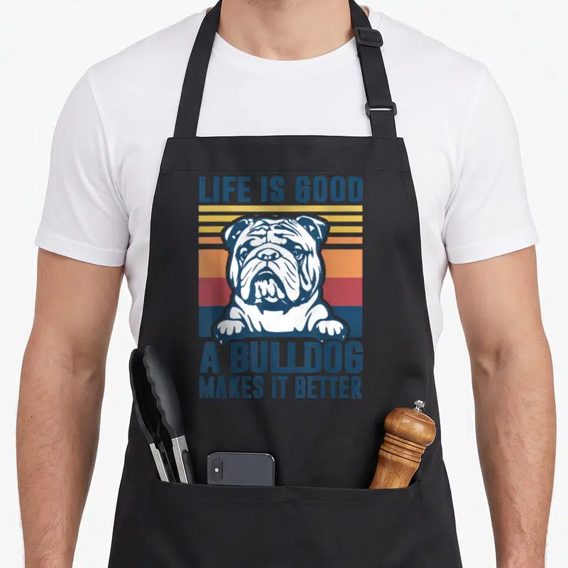 Dog english aprons - Retro bulldog portrait over blue yellow orange red and white stripes with LIFE IS GOOD text — shown on a black cotton canvas apron against a white background