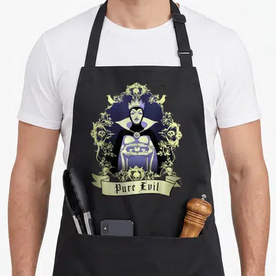 Snow queen apron - Evil Queen holding heart box in gold vine frame with Pure Evil text — shown on a black cotton canvas apron against a white background