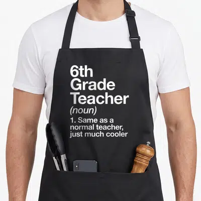 6th grade teacher apron - White stacked text reading 6th Grade Teacher definition on black bib apron — shown on a black cotton canvas apron against a white background