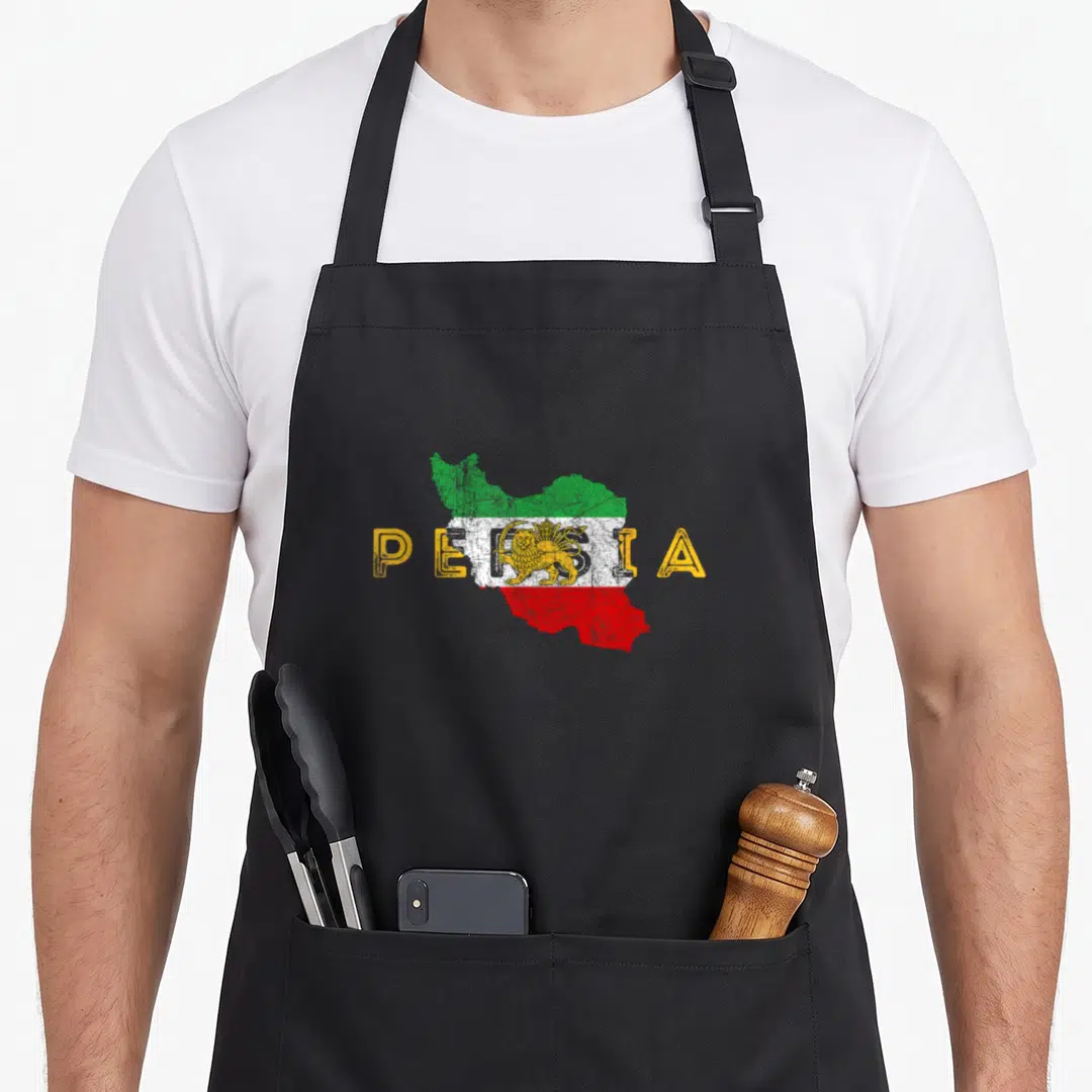 Persian distressed apron - Yellow PERSIA text over map of Iran with green white red stripes and lion sun emblem — shown on a black cotton canvas apron against a white background